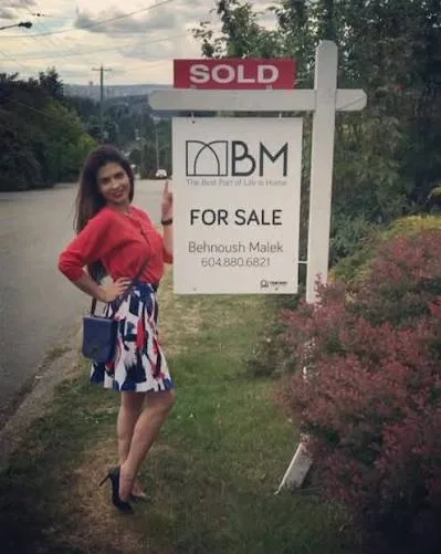 Behnoush Malek beside a SOLD sign on a North Shore street
